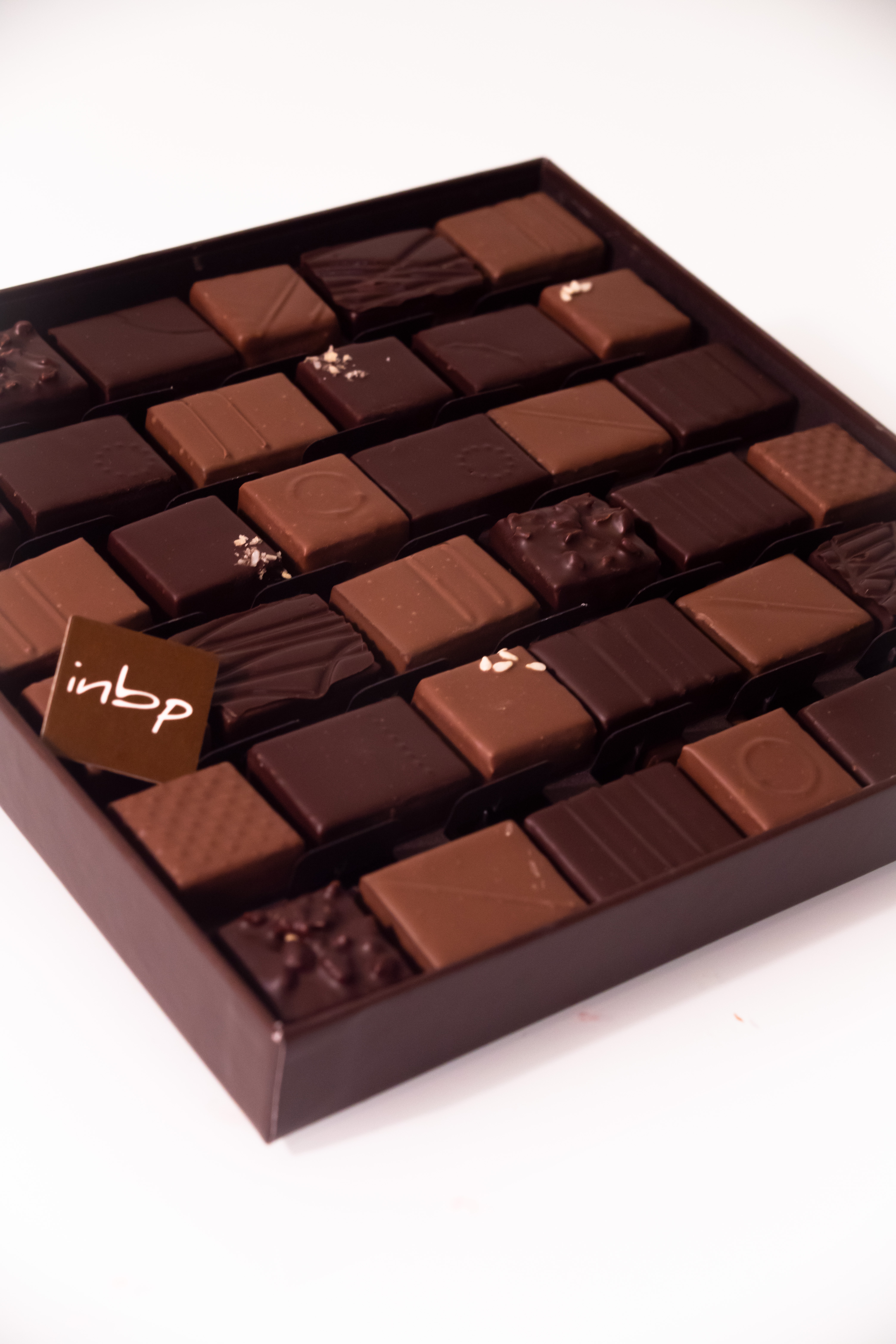 Photo au format portrait d'une boite contenant des chocolats carré créés par Jean-Pierre Godier de l'INBP de Rouen